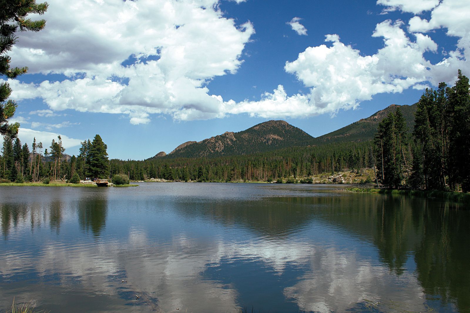 A calm mountain lake ringed by pines